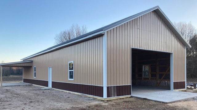 Tan metal pole barn with wide equipment entrance